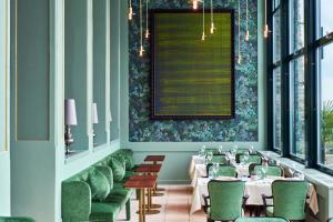 卢塞恩古奇城堡酒店的用餐室配有白色的桌子和绿色的椅子