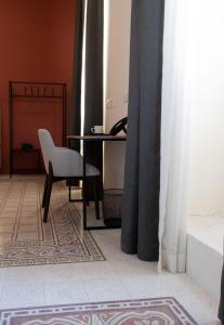 瓦莱塔Mulberry Suites的客房设有一张桌子、一把椅子和一部电话