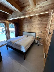 考恩台尔Chalet Chardonnay的卧室配有一张床铺,位于带木墙的房间内