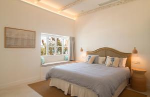 卡拉纳雅达海阁酒店的白色的卧室设有一张大床和一个窗户
