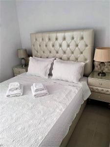 斯卡拉马里昂Prince Boutique Suite的一张白色的床,上面有两条毛巾