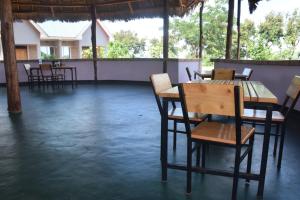 莫希Kili View Lodge的一间在房间内配有桌椅的餐厅
