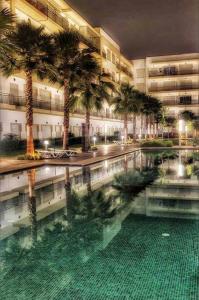 布兹尼盖superbe appartement en résidence balnéaire的一座棕榈树大建筑和游泳池