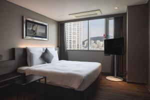 釜山广安里凯星顿肯特酒店的酒店客房设有一张床和一个大窗户