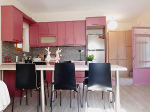 新安希亚洛斯Alba Traditional Countryhouse New Anchialos village的厨房配有粉红色橱柜和桌椅