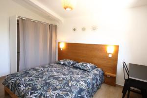 勒唐蓬Villa Pitaya的一间卧室配有一张床和一个木制床头板