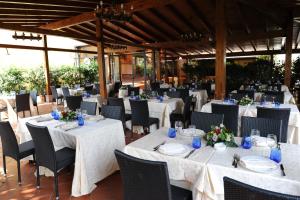 韦莱特里贝尼托阿尔博斯科酒店的一间设有白色桌椅的用餐室