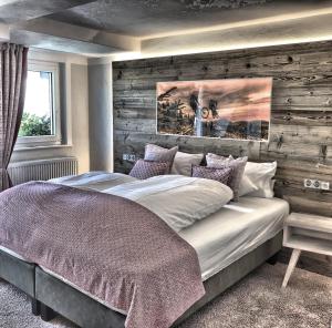 温特贝格Hotel Nuhnetal的一间卧室设有一张带木墙的大床