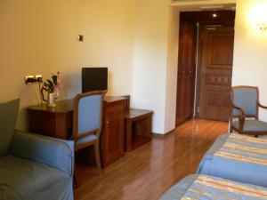 韦莱特里贝尼托阿尔博斯科酒店的酒店客房设有两张床、一张桌子和一张桌子。