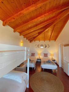 阿尔热祖尔The Lighthouse Hostel Arrifana的客房设有两张床和木制天花板。
