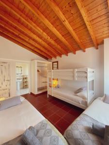阿尔热祖尔The Lighthouse Hostel Arrifana的一间卧室设有两张双层床和木制天花板。