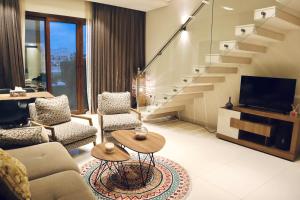 塞拉莱Casa Salalah, cozy 2-storey townhouse in Hawana Salalah with free Wi-Fi的带沙发和电视的客厅以及楼梯。