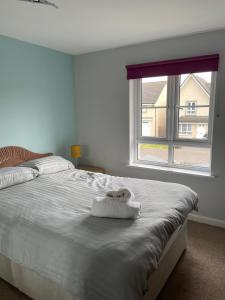 爱丁堡3 bed house with parking near airport的卧室配有一张大白色床和窗户
