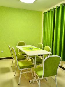 内罗毕Casa Tranquilla - JKIA的绿窗帘的房间的桌椅