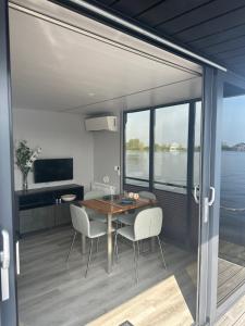 Belt-SchutslootStoere HOUSEBOAT op toplocatie!的一间带桌椅和大窗户的用餐室