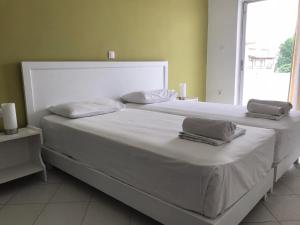 卡沃斯Kavos Central的一张带两个枕头的大白色床