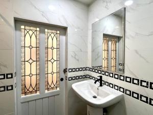 曼谷DiscoveryHome2 at Pratunammarket的白色的浴室设有水槽和镜子
