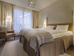 皮特奥阿姆斯皮特奥主教酒店的一间卧室配有一张大床和一把椅子