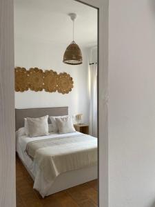 博罗尼亚Habitaciones Carmencita的卧室配有白色的床和镜子