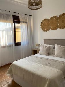 博罗尼亚Habitaciones Carmencita的卧室设有一张白色大床和一扇窗户。