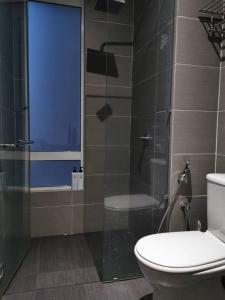 新山KSL D'Esplanade Cozy Suite at Johor的一间带卫生间和玻璃淋浴间的浴室