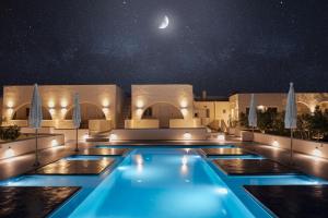 卡特瑞杜斯Zaitun Luxury Suites的夜晚的游泳池,天空中月亮