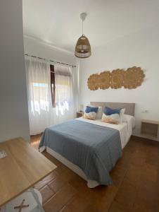 博罗尼亚Habitaciones Carmencita的一间卧室配有一张带蓝色毯子的大床
