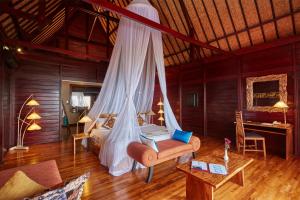 Haad PleayleamKupu Kupu Phangan Beach Villas & Spa by L'Occitane - SHA Plus的一间卧室配有一张带蚊帐的床