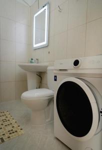 地拉那Villa Apartments S&F City Centre的浴室配有洗衣机、卫生间和水槽