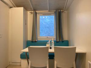 阿雷斯Mobile home Premium 24m² 2 chambres的一间带桌椅和窗户的用餐室