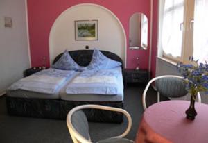 马林诺维德埃尔菲-旅馆的卧室配有一张床和一张桌子及椅子