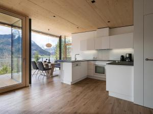 阿亨湖Ferienwohnung Auszeit am See的厨房配有白色橱柜和桌椅