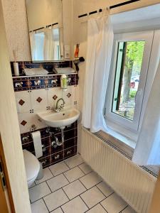 福森Pension Steakhaus Füssen的一间带水槽和卫生间的浴室以及窗户。