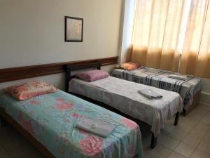 萨尔瓦多Hotel Minas Salvador的客房设有两张床和窗户。