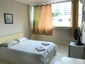 萨尔瓦多Hotel Minas Salvador的一间卧室设有一张床和一个窗口