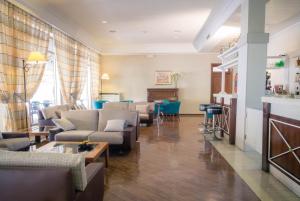 特拉西梅诺湖畔帕西尼亚诺利多酒店的客厅配有沙发和桌子。