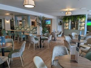 利明顿Shorefield Country Park Self-Catering Holiday Home的一间带桌椅的餐厅和一间酒吧