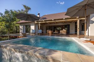 侯斯普瑞特Ukanyi Luxury Villa的一座房子后院的游泳池