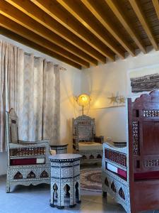 阿卡Bab al-sham funduk的客厅配有椅子、桌子和窗帘
