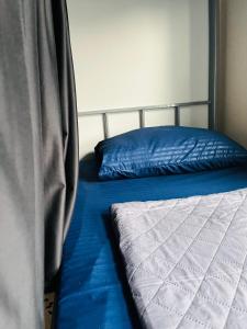 阿布扎比Paradiso Backpackers Nest 1的一张带蓝色床单和蓝色枕头的床
