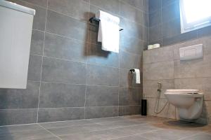 杜阿拉VOAK Home的一间带卫生间和瓷砖墙的浴室