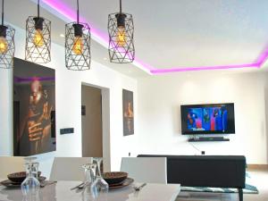 杜阿拉VOAK Home的一间带桌子和平面电视的用餐室