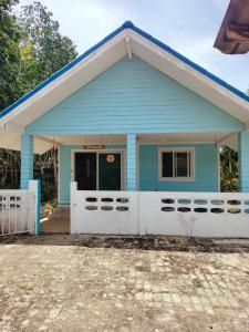 Baan Namthip Homestay Trang บ้านน้าทิพย์ โฮมสเตย์ตรัง的蓝色房子,设有白色车库