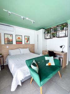 圣保罗Apartamento para renovar as energias - Cama Queen的一间卧室配有一张床和一张绿色沙发