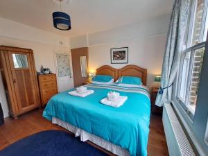 伦敦麦斯威山住宿加早餐旅馆的一间卧室配有蓝色的床和毛巾