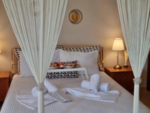 美西尼Phivos Home & Garden的一间卧室配有白色窗帘的床
