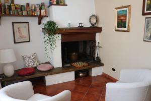 卢卡Casa Marcobando的客厅设有壁炉和2把白色椅子