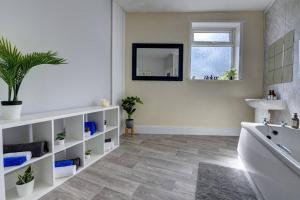 Skegby6 bedrooms, sleeps up to 16, secure parking space & comfort的带浴缸、水槽和镜子的浴室