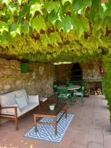 赫罗纳Els Masos de Caula的绿树下带桌椅的天井