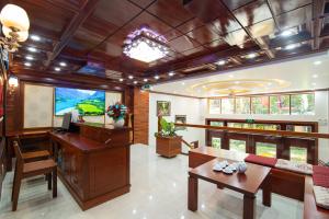 洞海Minh Quang Hotel的客厅配有电视、书桌和桌子